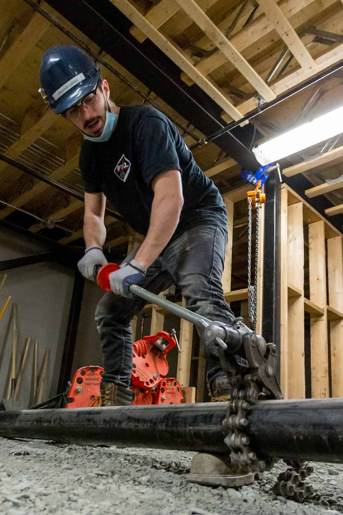 technicien alamo-sarl travaillant sur un tuyau chantier intérieur à Limoux avec équipement de sécurité,