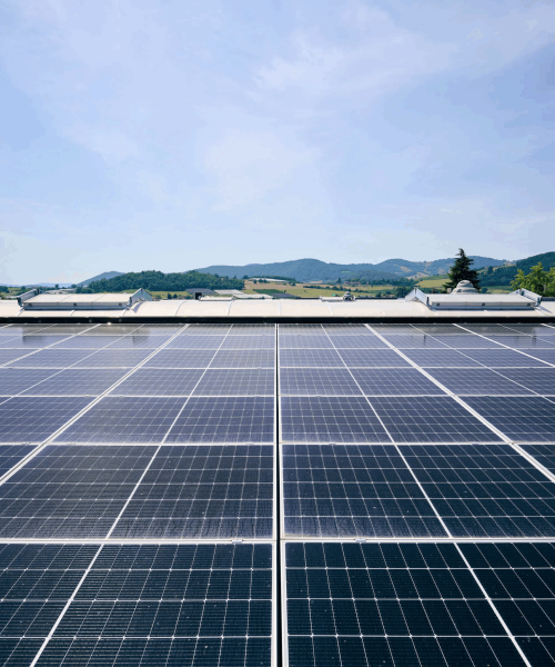 Panneaux solaires installés par alamo-sarl sur toit plat à Limoux avec paysage vallonné en arrière-plan,
